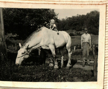 White baby on a big horse, man stands by