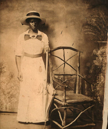 Unknown Black woman posing near a chair