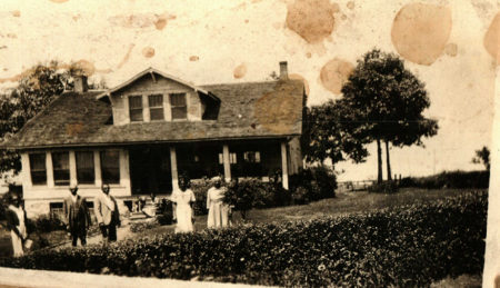 Five Black people standing in front of a house